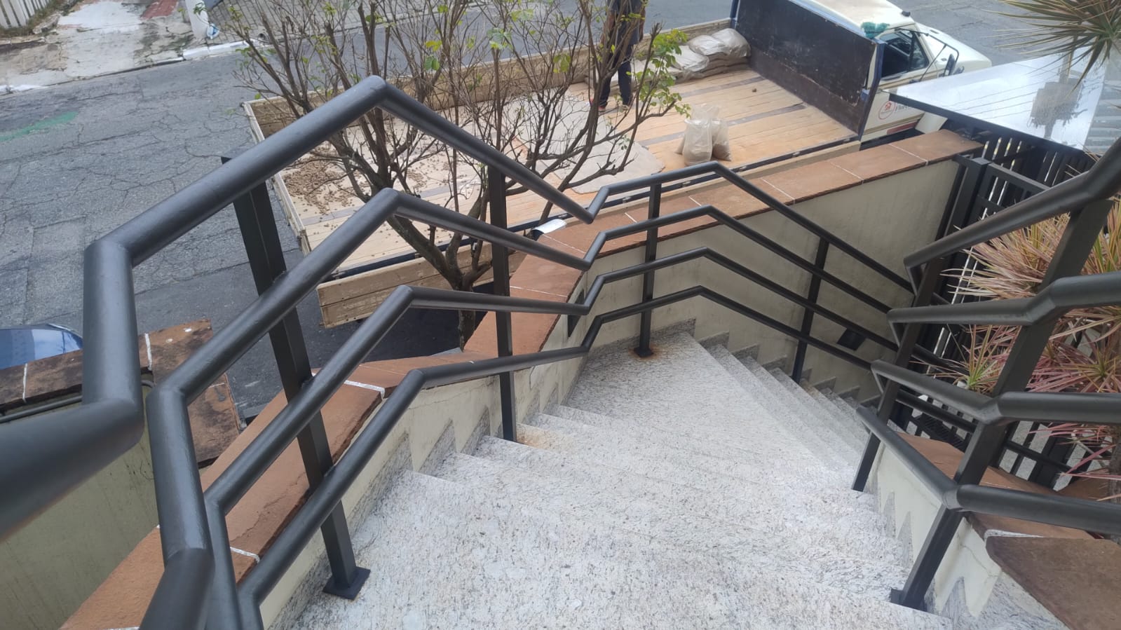 Escada metálica preta e grade de proteção em janela
